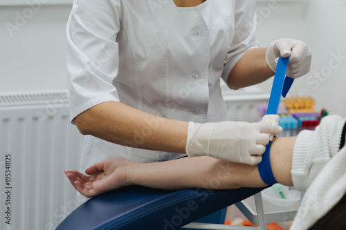 Tightening the harness on the arm before taking blood. Manipulation cabinet. Hematology. Health and medicine.