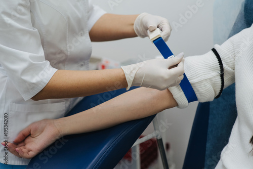 Tightening the harness on the arm before taking blood. Manipulation cabinet. Hematology. Health and medicine.