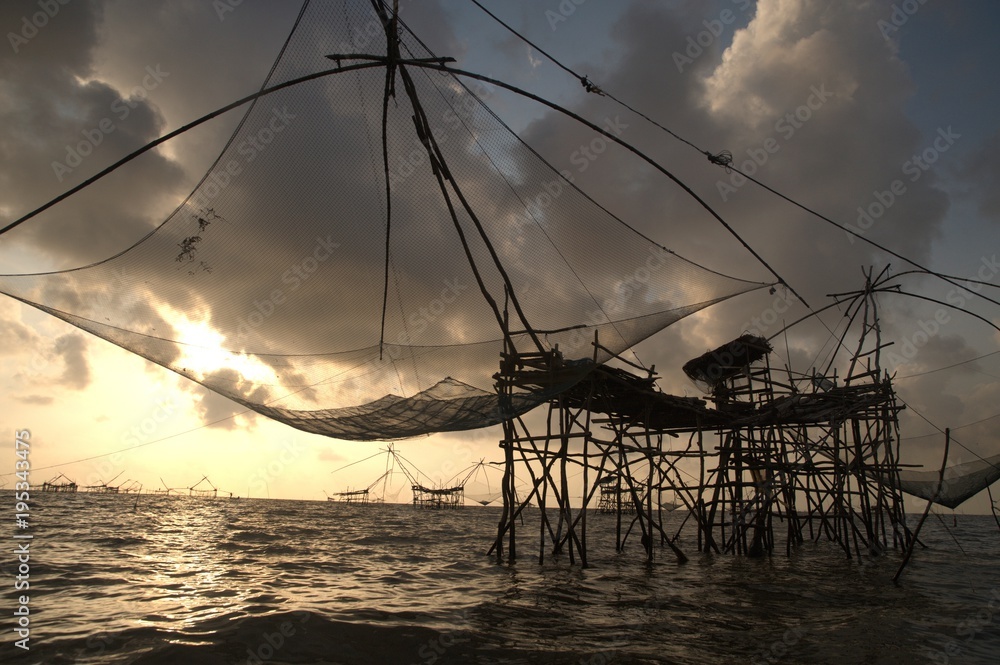 Twilight view of square dip net or Yo made of bamboo in sunset time at Ban Pak Pra -Talay Noi Lake, Phatthalung, Thailand.