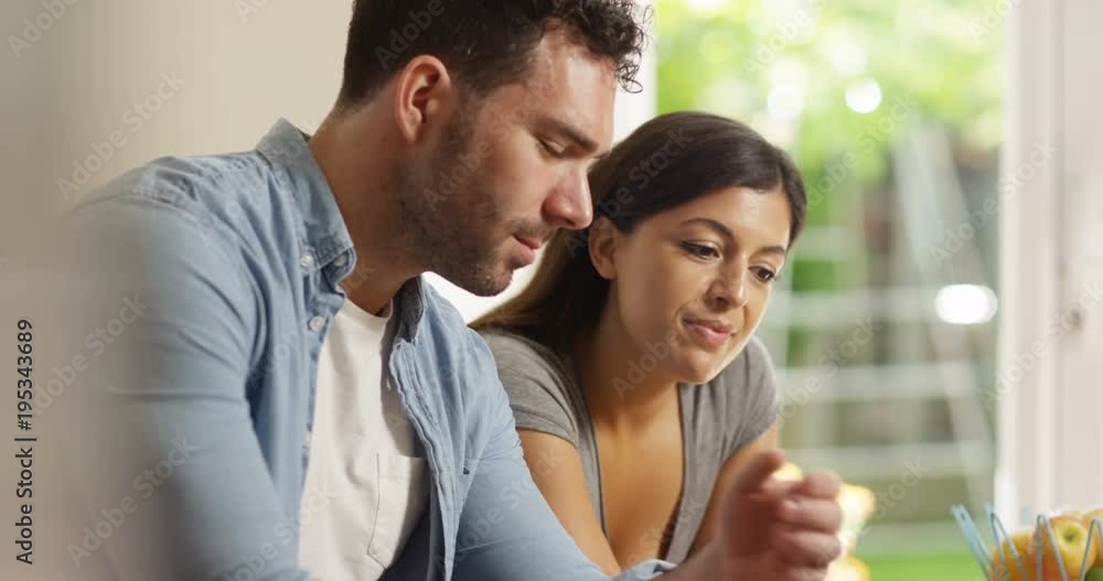 4K Attractive mixed ethnicity couple browsing the internet together at home 4K Attractive mixed ethnicity couple browsing the internet together at home
