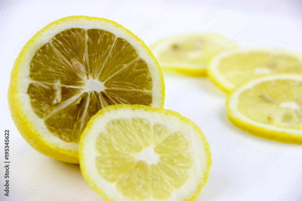 bright, yellow lemons. whole and sliced on a plate. bright, yellow lemons. whole and sliced on a plate.