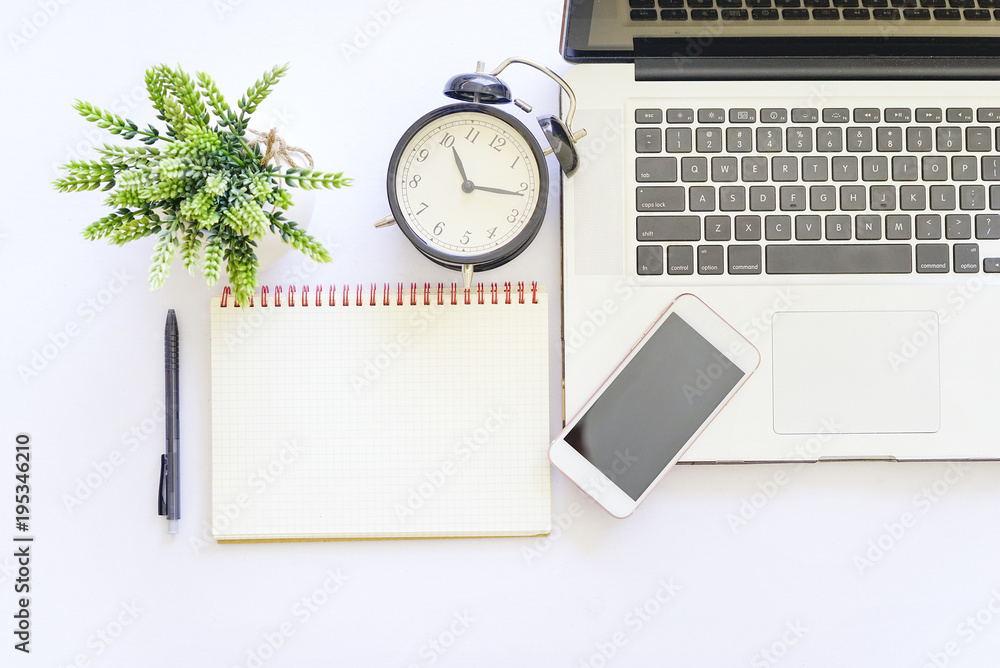 Flat lay top view of white table with notebook, a pen, smartphone and green plant. Flat lay top view of white table with notebook, a pen, smartphone and green plant.