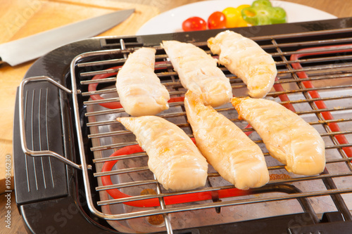 chicken breasts fillet on electric barbecue and grill