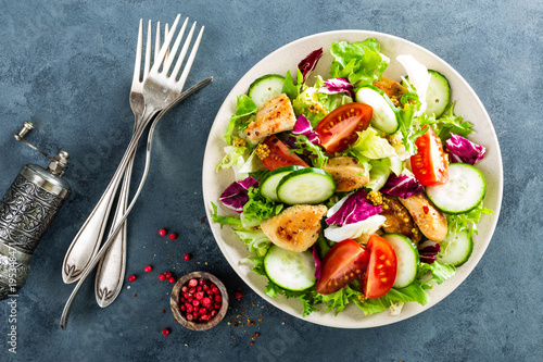 Fresh vegetable salad of tomatoes, cucumbers, italian mix, lettuce and grilled chicken breast