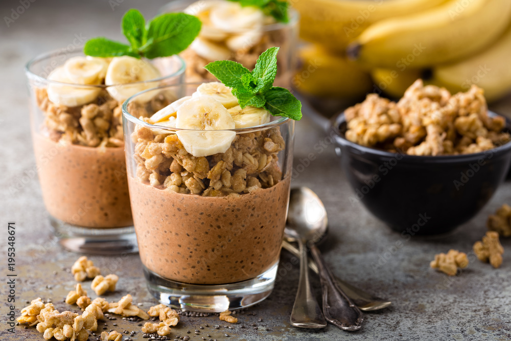 Layered chocolate chia pudding parfait with banana, granola and yogurt, dessert Layered chocolate chia pudding parfait with banana, granola and yogurt, dessert