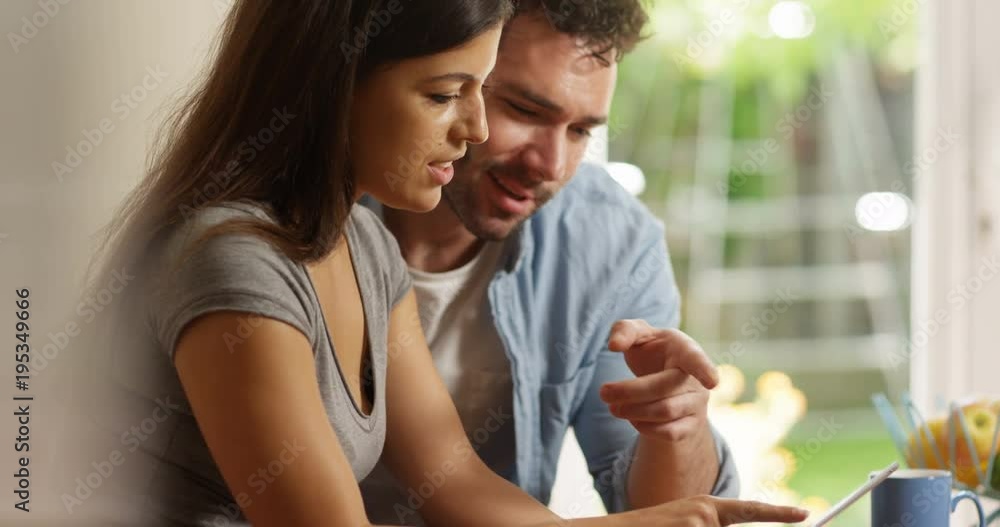 4K Happy couple doing internet search at home using computer tablet