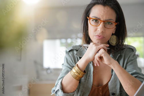 Brunette girl with eyeglasses looking at camera with skeptic look