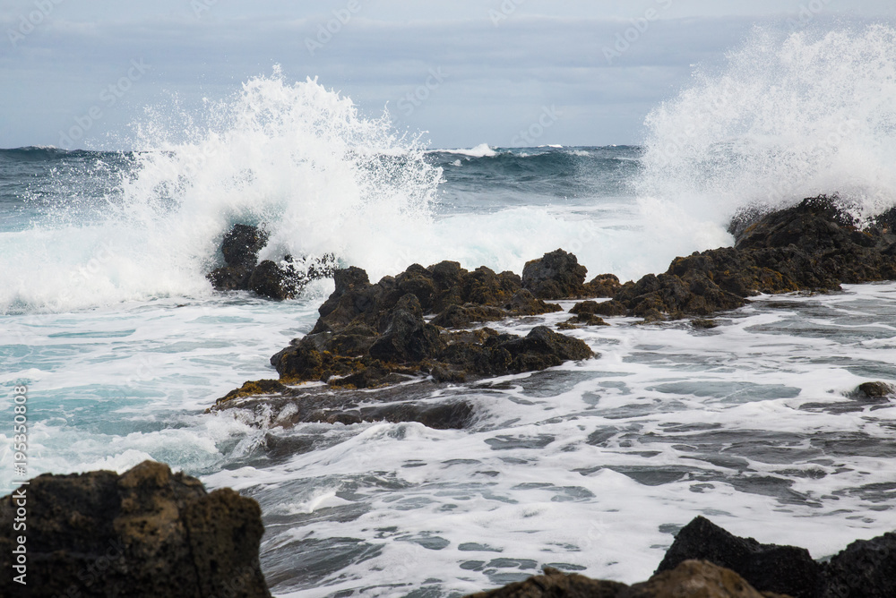 Waves Crashing Over Rocks On A Beach On The Island Of Oahu Waves Crashing Over Rocks On A Beach On The Island Of Oahu