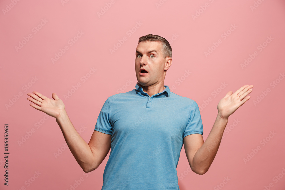 The young attractive man looking suprised isolated on pink The young attractive man looking suprised isolated on pink