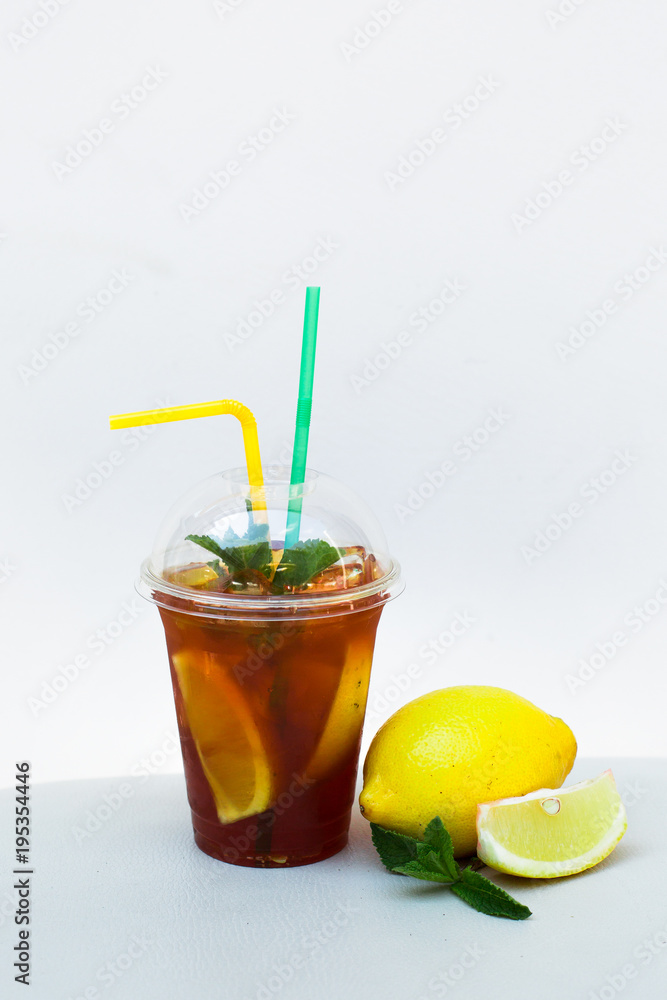 Ice tea with lemon and mint in a plastic cup with straws Stock Photo