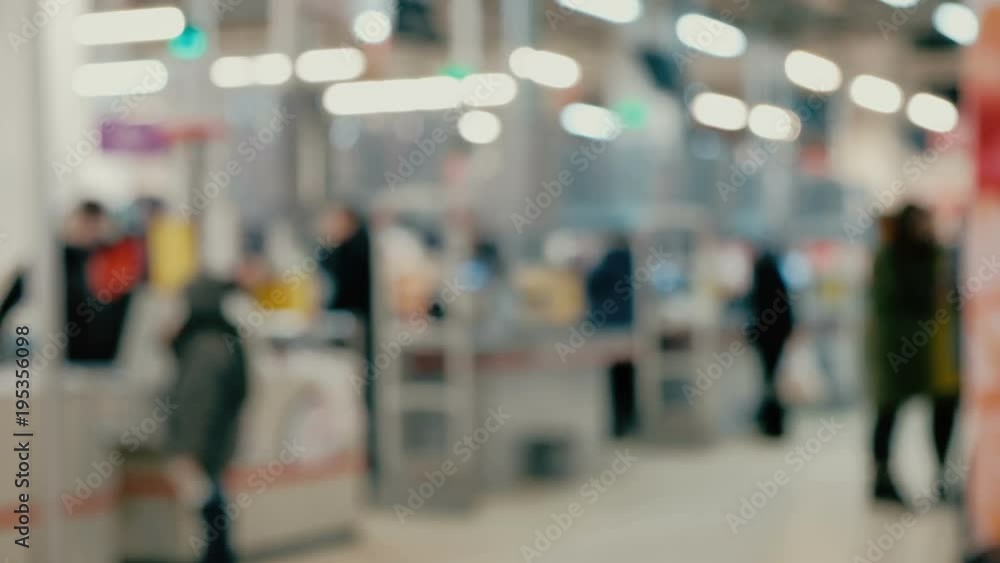 Defocused customers pay for goods in mall and go out Defocused customers pay for goods in mall and go out
