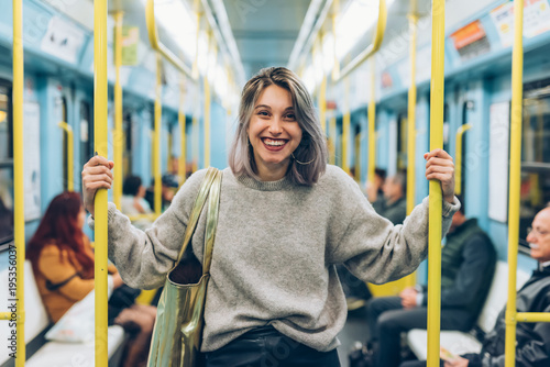 waist up young woman travelling underground looking camera smiling - traveller, commuter, happiness concept