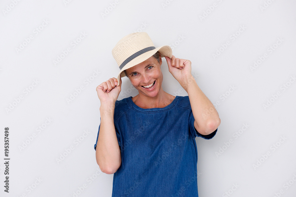 happy older woman laughing with hat against white background