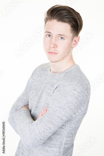 Portrait of smart serious young man standing against grey white background
