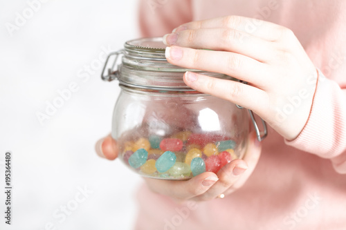 hand with jar of red jelly bean