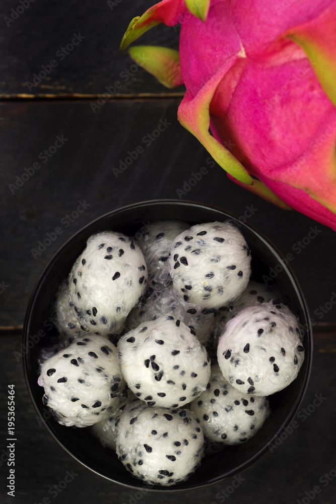 Dragon fruit balls in a black bowl seen from above