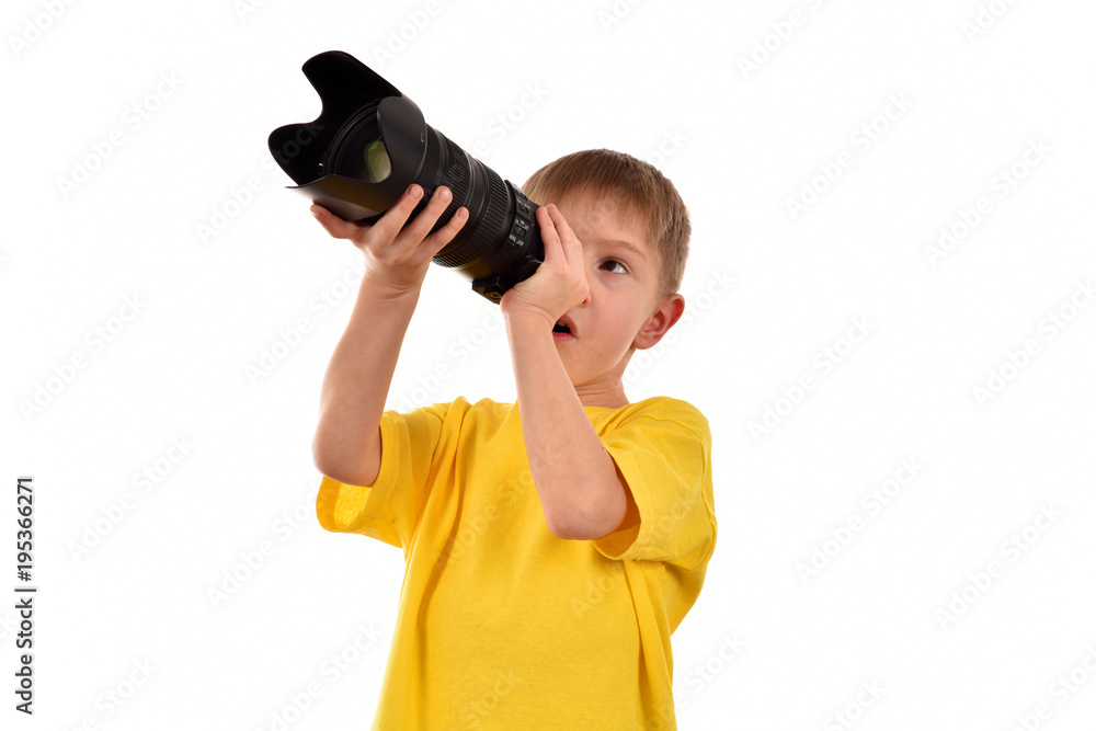 A young boy is looking into the lens. A young man is a photographer.Isolated child on a white background. A young boy is looking into the lens. A young man is a photographer.Isolated child on a white background.