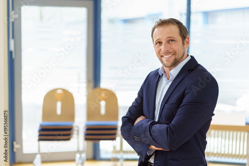 Smiling happy businessman standing daydreaming