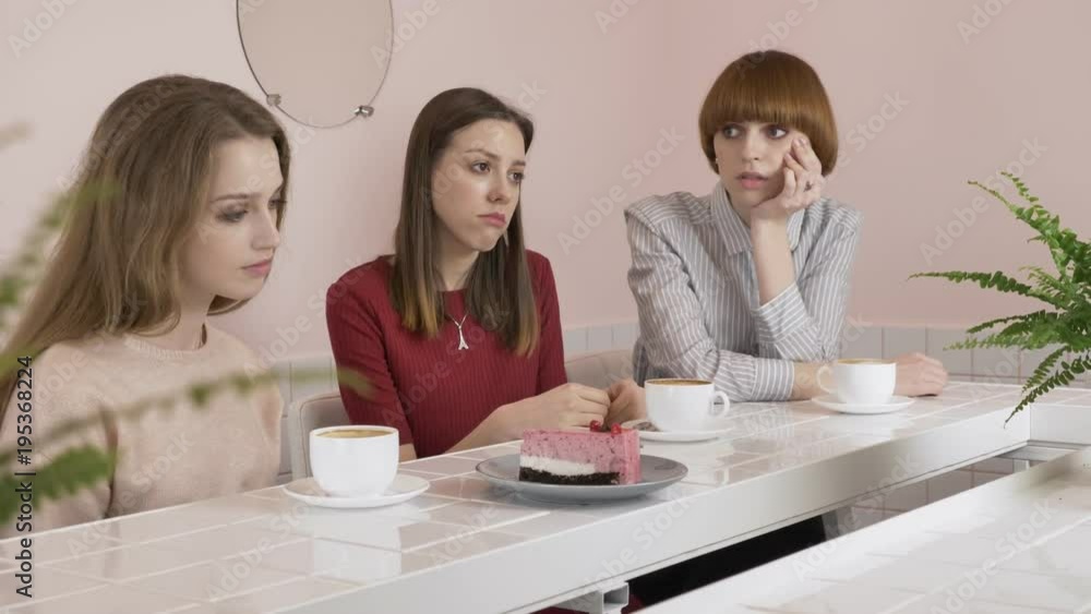 Three young Caucasian girls sitting in a cafe, drinking coffee, eating cake, sad, gesturing with their hands, gossip old girlfriends in a cafe concept. 60 fps Three young Caucasian girls sitting in a cafe, drinking coffee, eating cake, sad, gesturing with their hands, gossip old girlfriends in a cafe concept. 60 fps