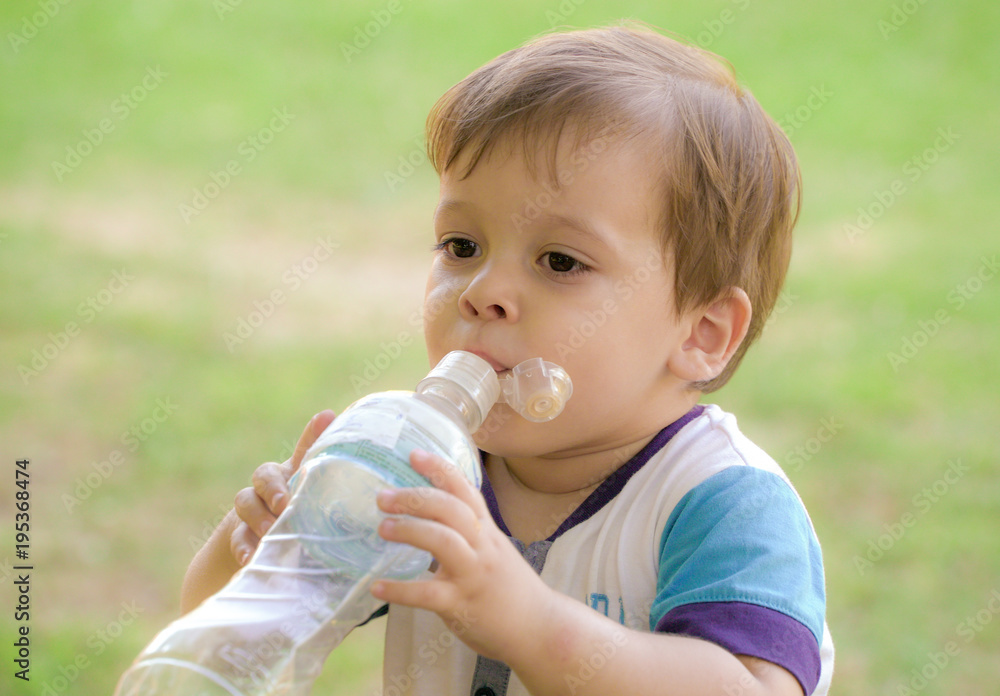 baby with a bottle of water in the park baby with a bottle of water in the park