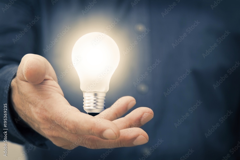 hand holding the light bulb on, concept of idea and creativity hand holding the light bulb on, concept of idea and creativity