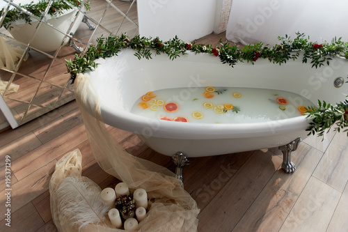 Elegant roll-top bath and decorated with flowers. In the water swim citrus. The atmosphere of relaxation  relaxation