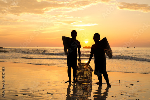 kids playing at the beach during sunset.