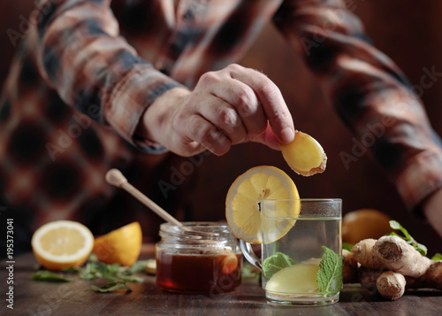 Ginger tea with honey , lemon and mint on old wooden table .