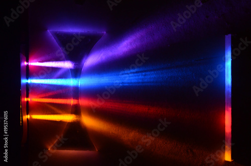 Fotografie Light beams in colorblind-friendly colors pass trough a concave demonstration le