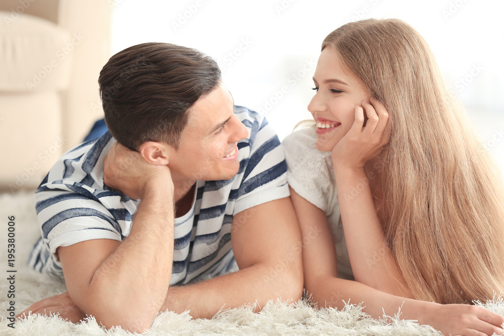 Young couple lying on carpet at home Young couple lying on carpet at home