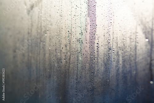 Flowing down water drops on window glass © Amelia Fox