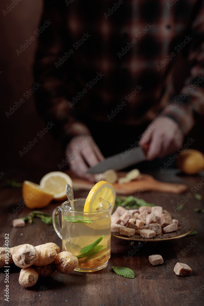 Ginger tea with brown sugar , lemon and mint on old wooden table . Ginger tea with brown sugar , lemon and mint on old wooden table .