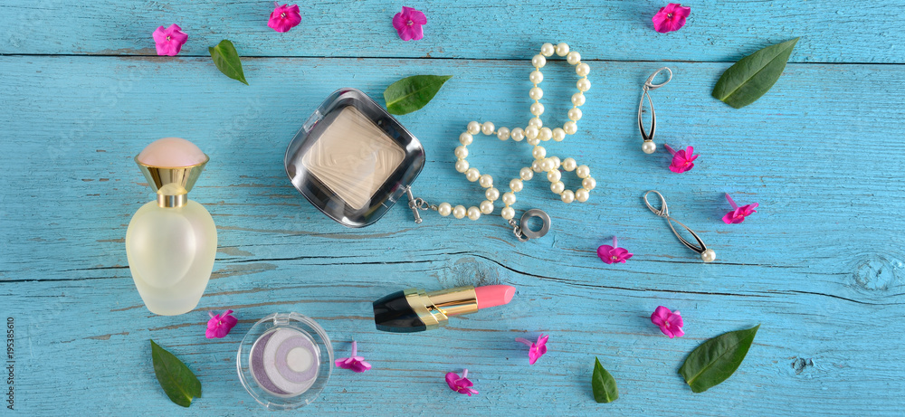 Cosmetics, perfumes and jewelry made of pearls on an old wooden background of blue color. Wide photo. Cosmetics, perfumes and jewelry made of pearls on an old wooden background of blue color. Wide photo.