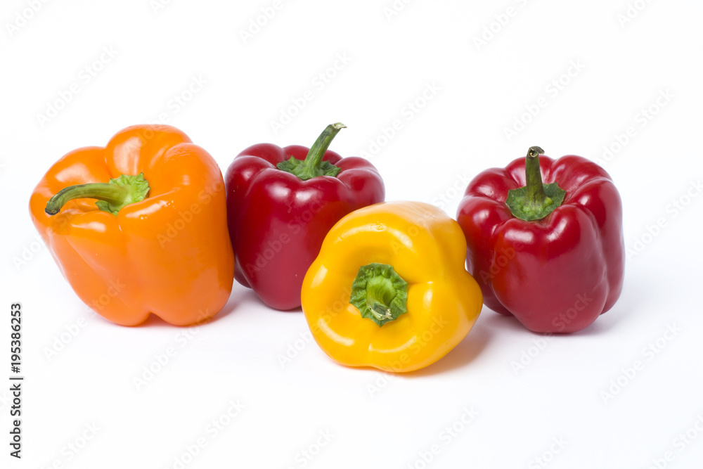 Red yellow and orange peppers on a white background..Multicolored vegetables in a composition on an abel background. Red yellow and orange peppers on a white background..Multicolored vegetables in a composition on an abel background.