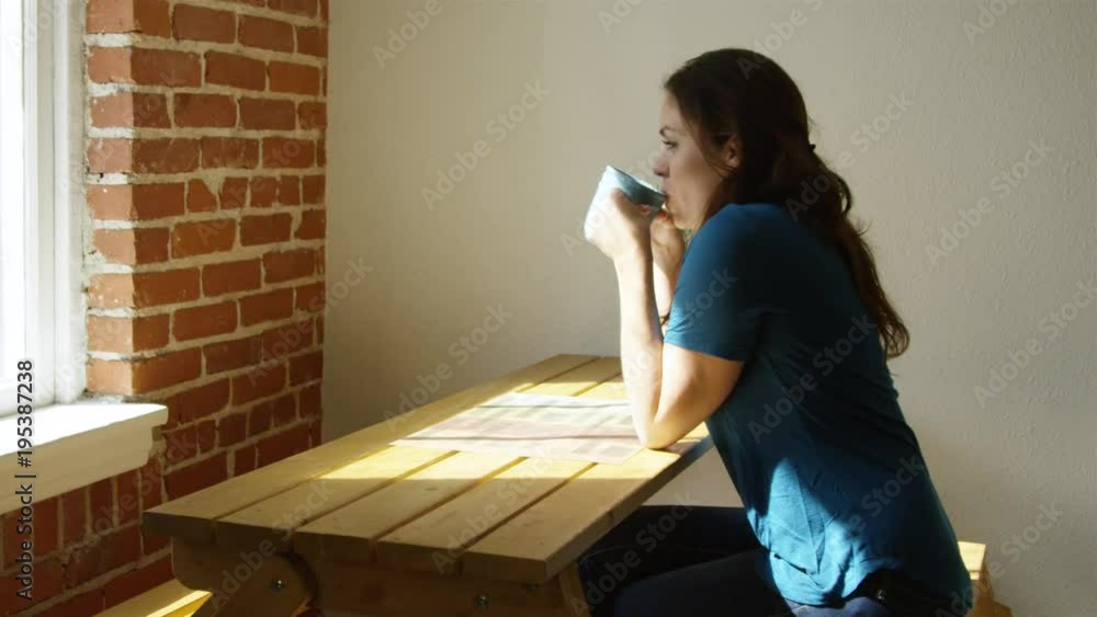 Slow motion shot of woman at home enjoying a cup of coffee in the morning Slow motion shot of woman at home enjoying a cup of coffee in the morning