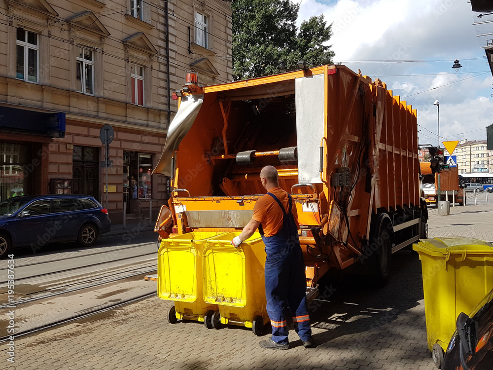 A public utility worker collects garbage from garbage cans in a garbage