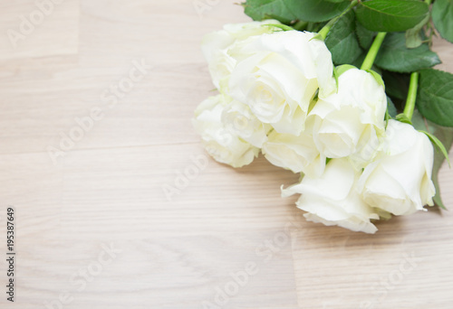 Bunch of beautiful white roses on wooden background. © taaree