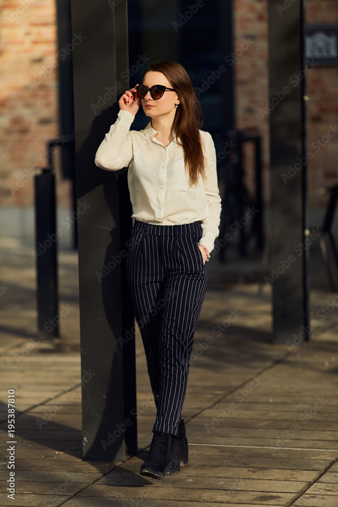 Fototapeta premium Young pretty woman walk on the street wear glasses and office clothing, spring time