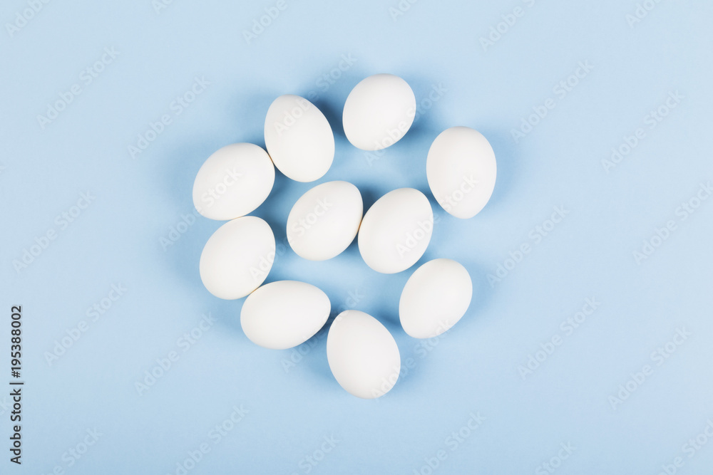 White eggs on blue background. Top view