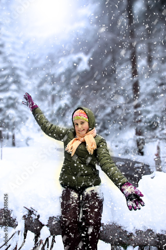 Happy young girl in snowy forest