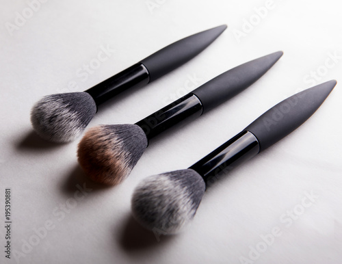 three brushes for powder on white background