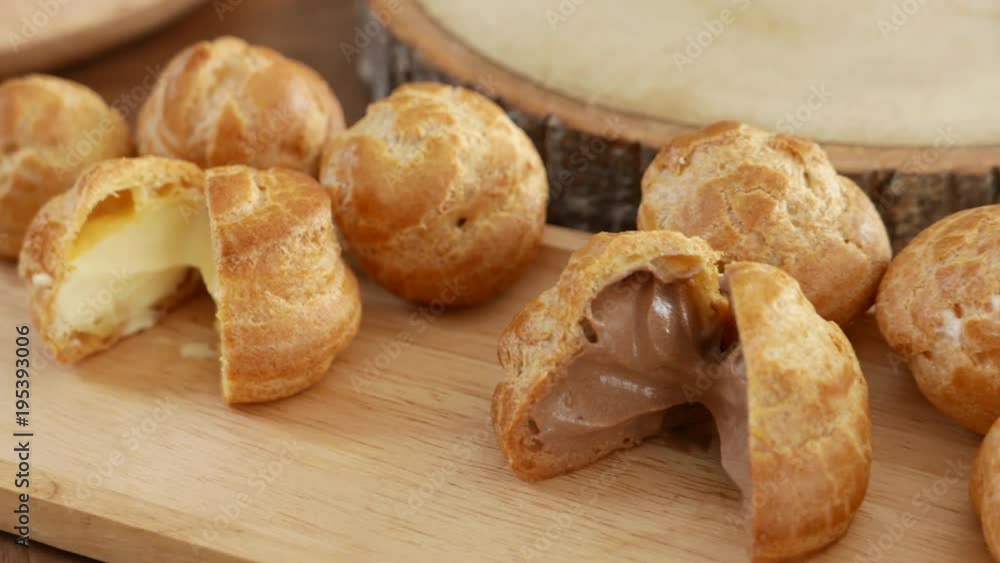 fresh baked cream puff or profiterole or choux creme showing sweet and moist filling whipped cream inside. fresh baked cream puff or profiterole or choux creme showing sweet and moist filling whipped cream inside.