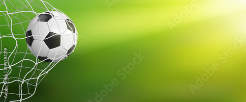 soccer ball in goal on green background photo