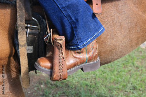 Young girl is saddled up and ready to help out by checking the cattle