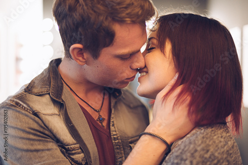 Man kissing his woman touching her cheek