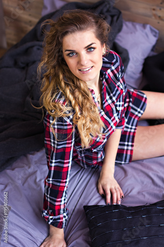 Beautiful blondie girl in bed. In the plaid shirt