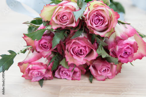 Bunch of beautiful pink roses on wooden background.