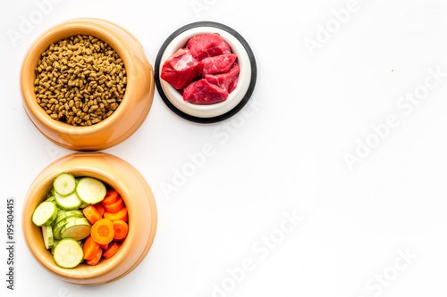 Ingredients for dry pet food. Meat and vegetables zucchini and carrot on white backgroud top view copy space