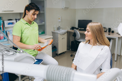 The dentist teaching a girl oral hygiene on braces in a dental clinic.