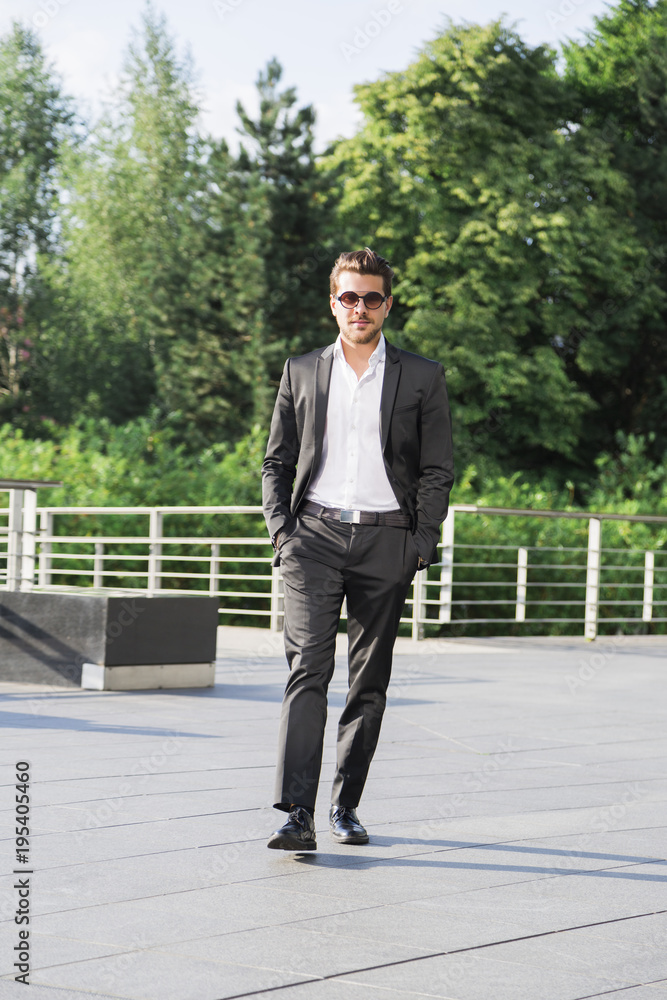 Male businessman or worker in black suit walk on the street